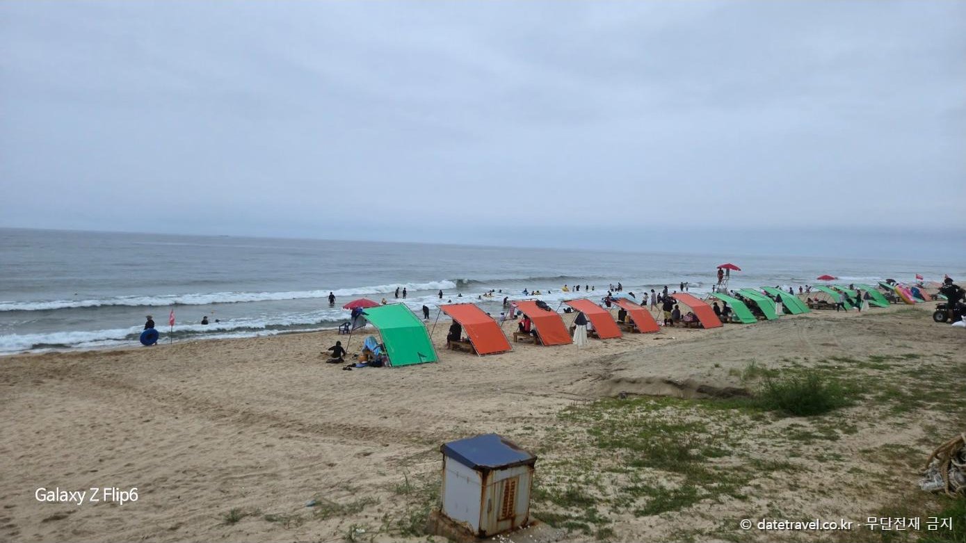 지경리 해수욕장 백사장과 그늘막 텐트 전경